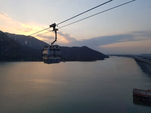 I snapped this photo as we were in the cable car going down the mountain: you can see another cable car going up the mountain beside us and the water below. The sun is setting and the sky is very pretty 