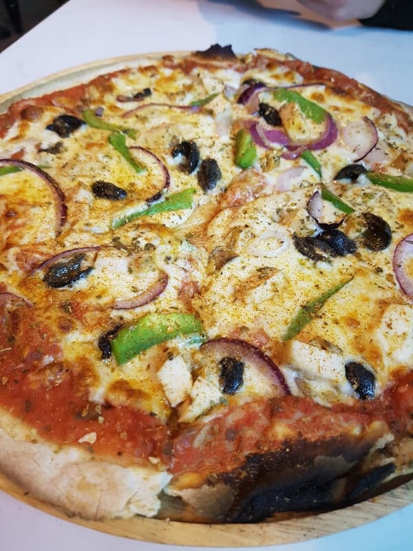 a cajun chicken pizza with peppers and onions 