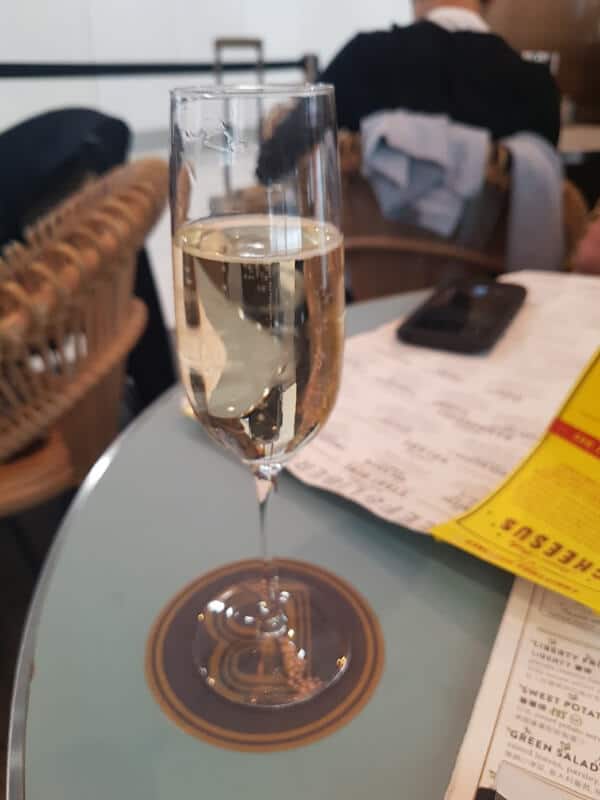 a glass of champagne at Beef and Liberty in the HK airport 