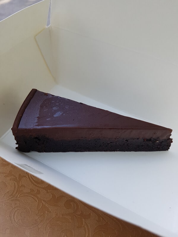 a slice of chocolate cake in a white box 