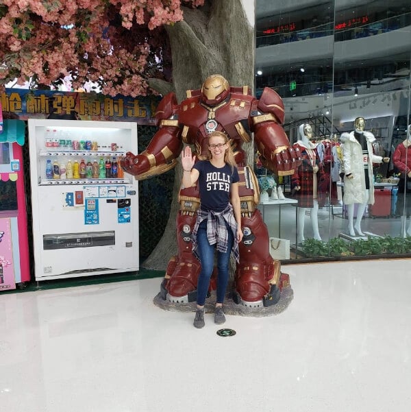 I am in the mall standing next to a figure of Iron Man and I am making an iron man pose