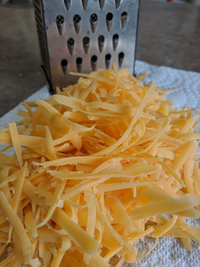 A pile of shredded cheddar cheese.