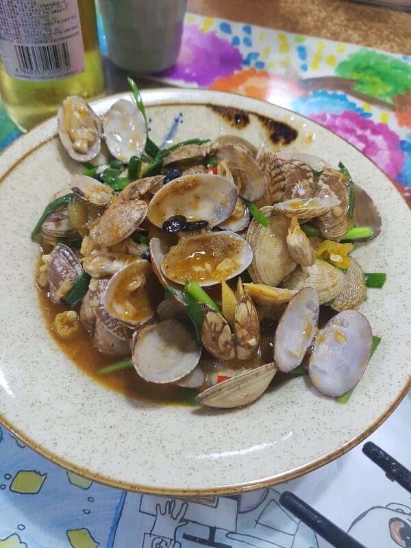 clam dish with a buttery sauce and green onions 