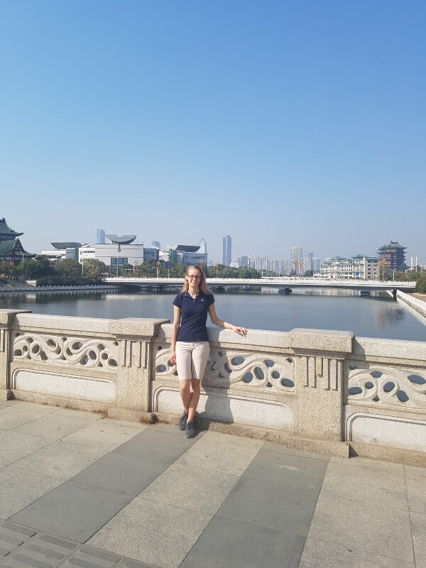 I am standing on a bridge with the river and buildings in the background 