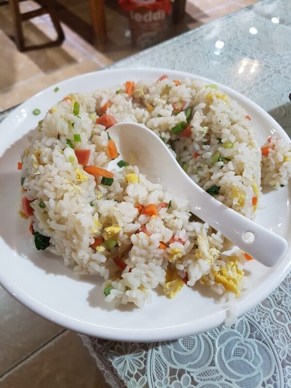 a bowl of rice with carrots, scrambled eggs, and green onions