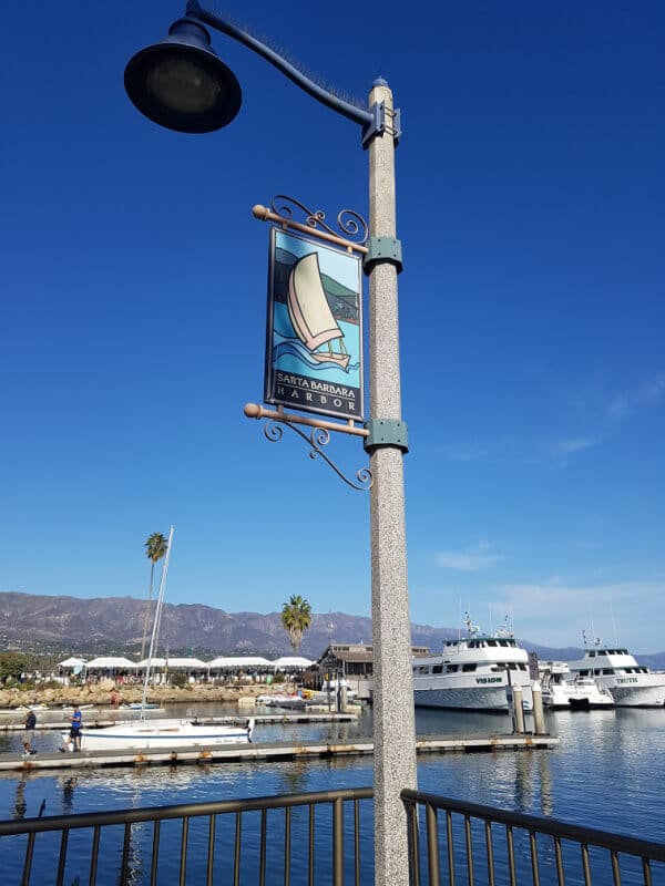 Southern California Itinerary: the Santa Barbara Harbor flag with a view of the harbor in the background 