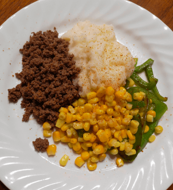 Cajun hamburger with mashed potatoes and corn and green peppers