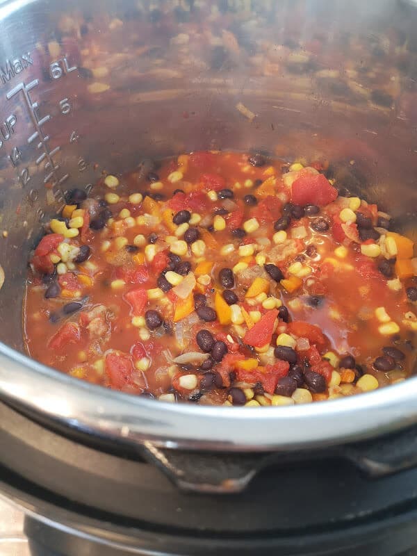 Easy Instant Pot Chicken Tortilla Soup: the instant pot is full of beans, corn, tomatoes and spices
