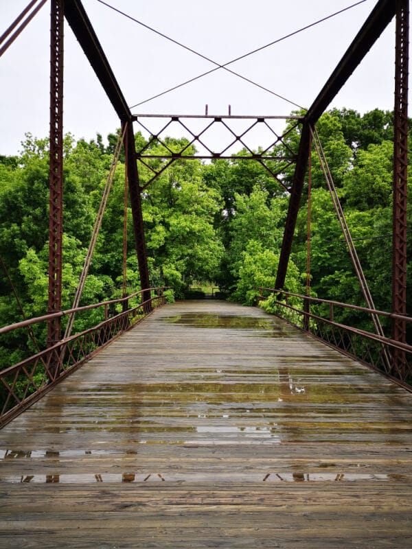 My Top 10 Moments of 2020: a photo of the bridge at Elk Falls in Elk City KS. There are green trees on the other side of the wooden bridge.