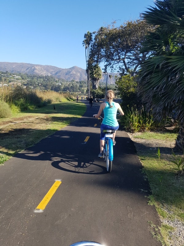 I am riding a bike in Santa Barbara, CA with the mountains in the distance.