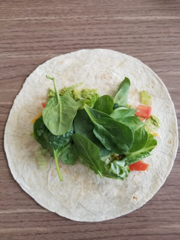 How to make Vegetarian Wraps Recipe: A wrap with avocado, cheese, sauted mushrooms, spinach, lettuce, cucumbers and tomatoes ready to be folded!