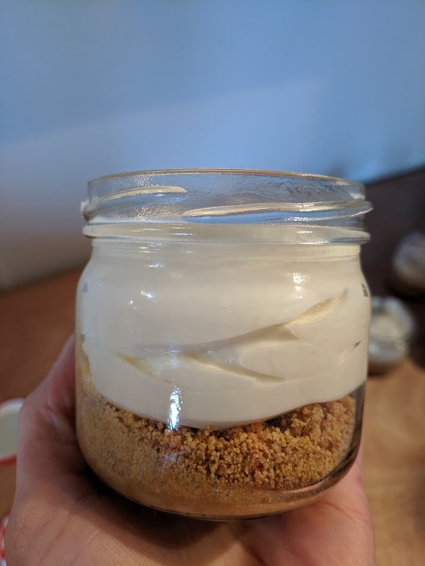 A picture of what No Bake Cheesecake Jars should look like before you put them in the fridge. A nice layer of graham crumbs and the cream cheese filling on top.