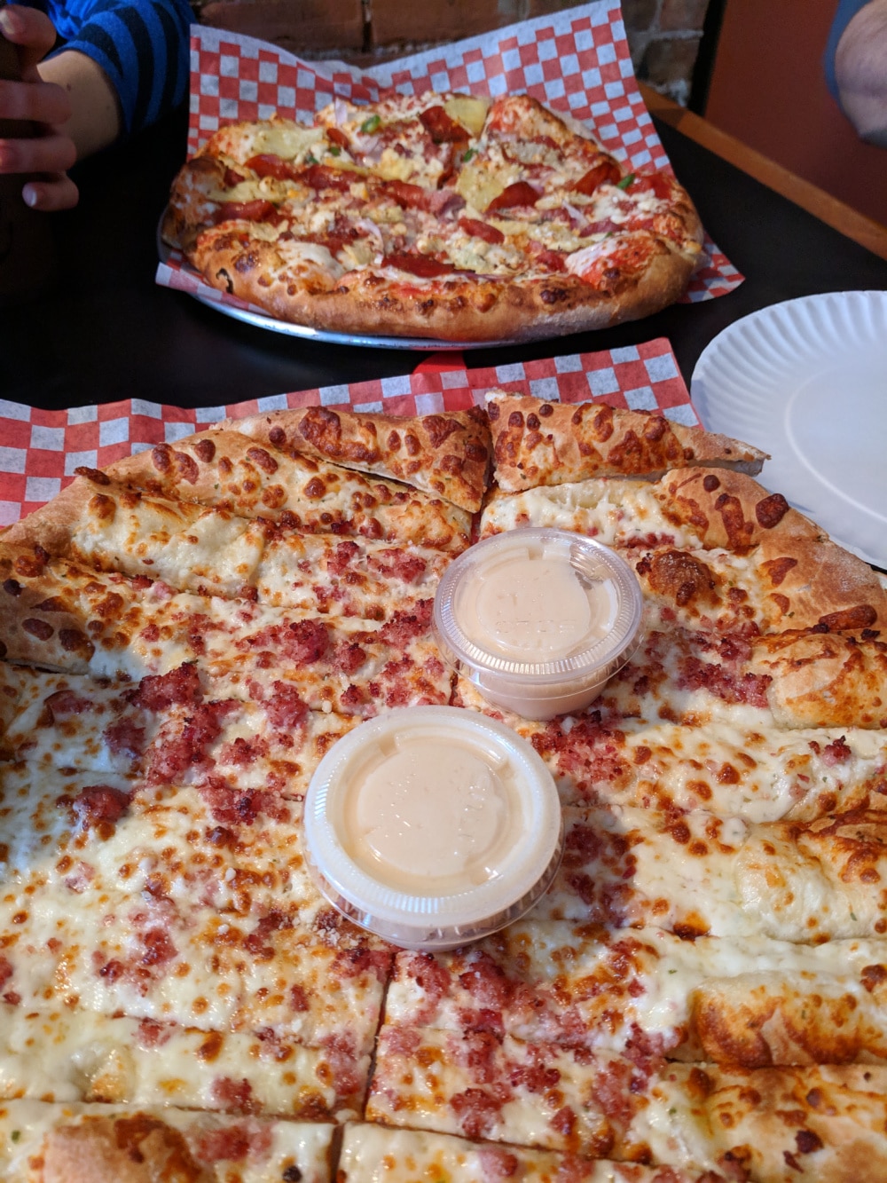 Pizza and garlic fingers. The garlic fingers have bacon and cheese and the pizza has pineapple, peppers and ham. 