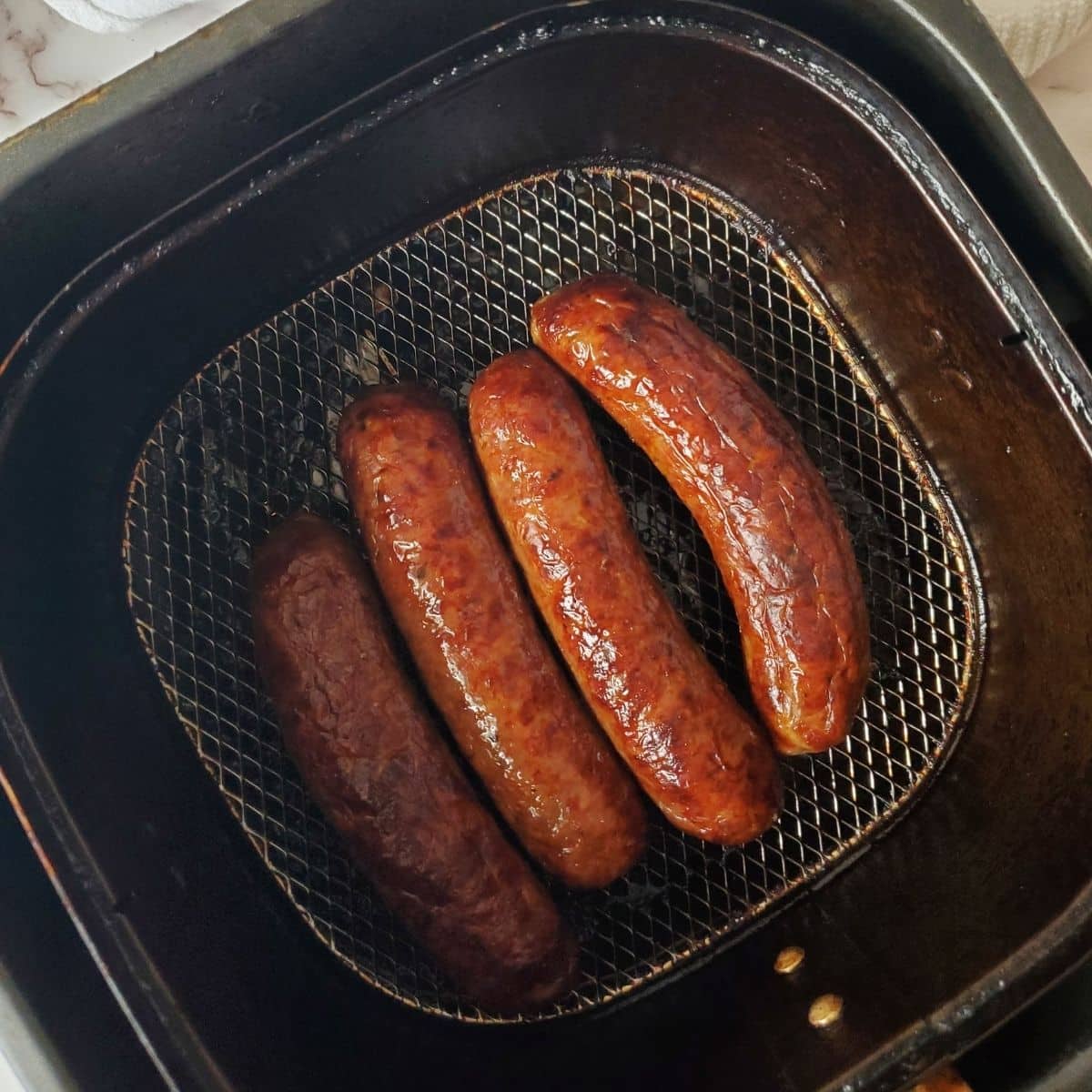 4 cooked Italian sausages in the air fryer. 