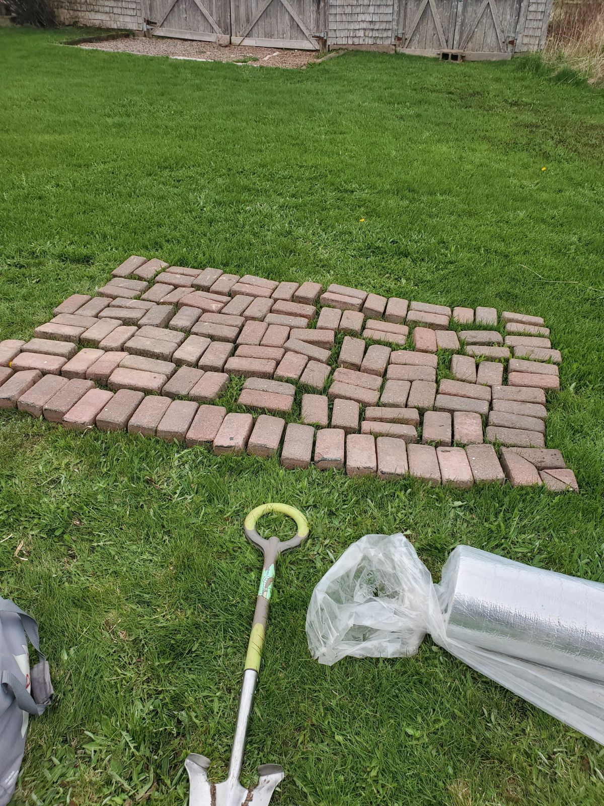 A photo of one of my landscaping jobs. A few rows of bricks laid out on the grass. 